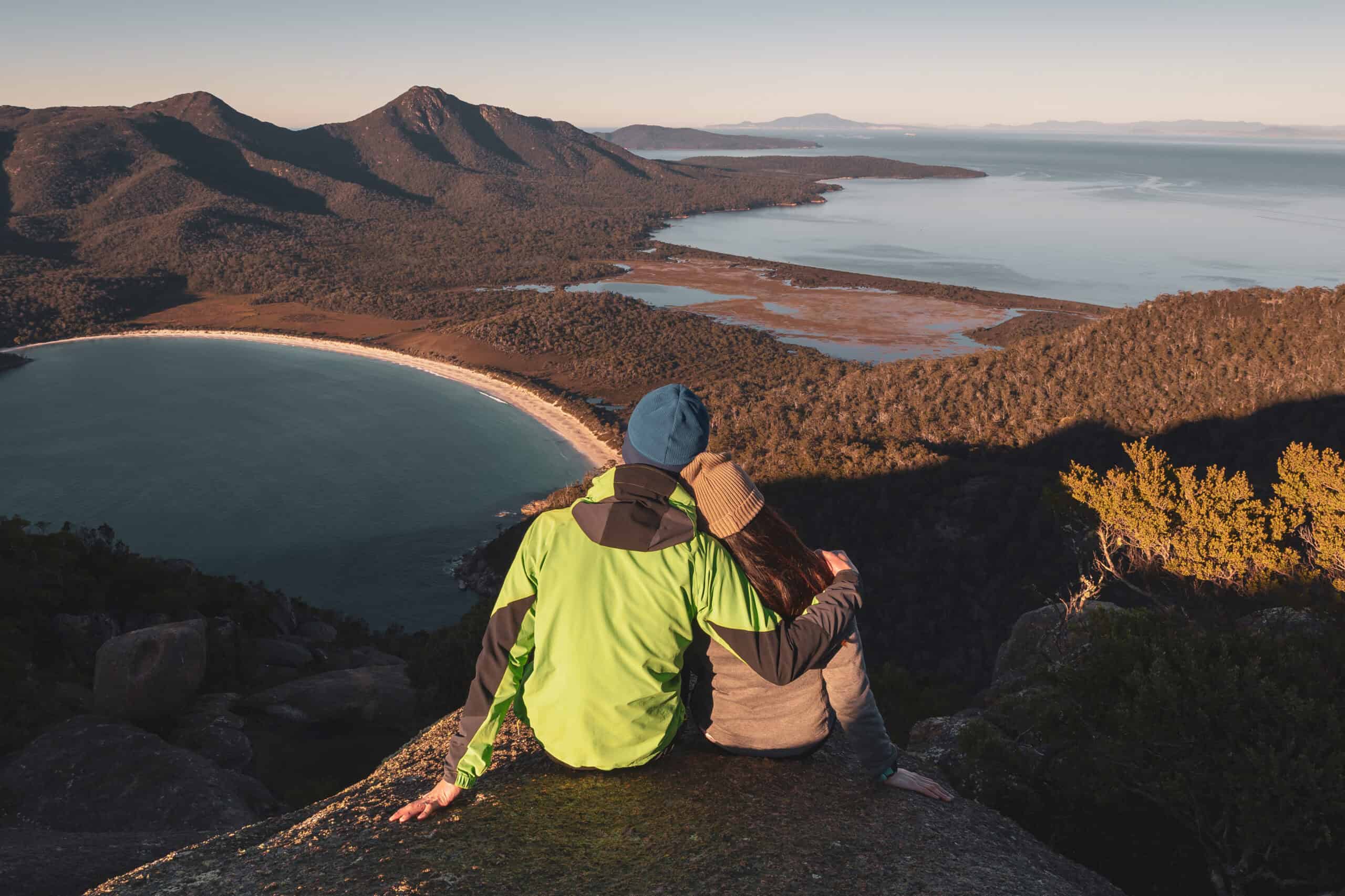 A pair of traveller couple watching sunrise at the peak of Mount